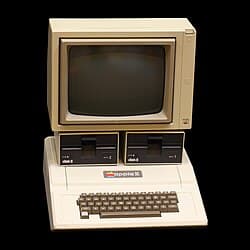 Illustration eines frühen beigen Heimcomputers mit farbiger Grafik auf dem Bildschirm.